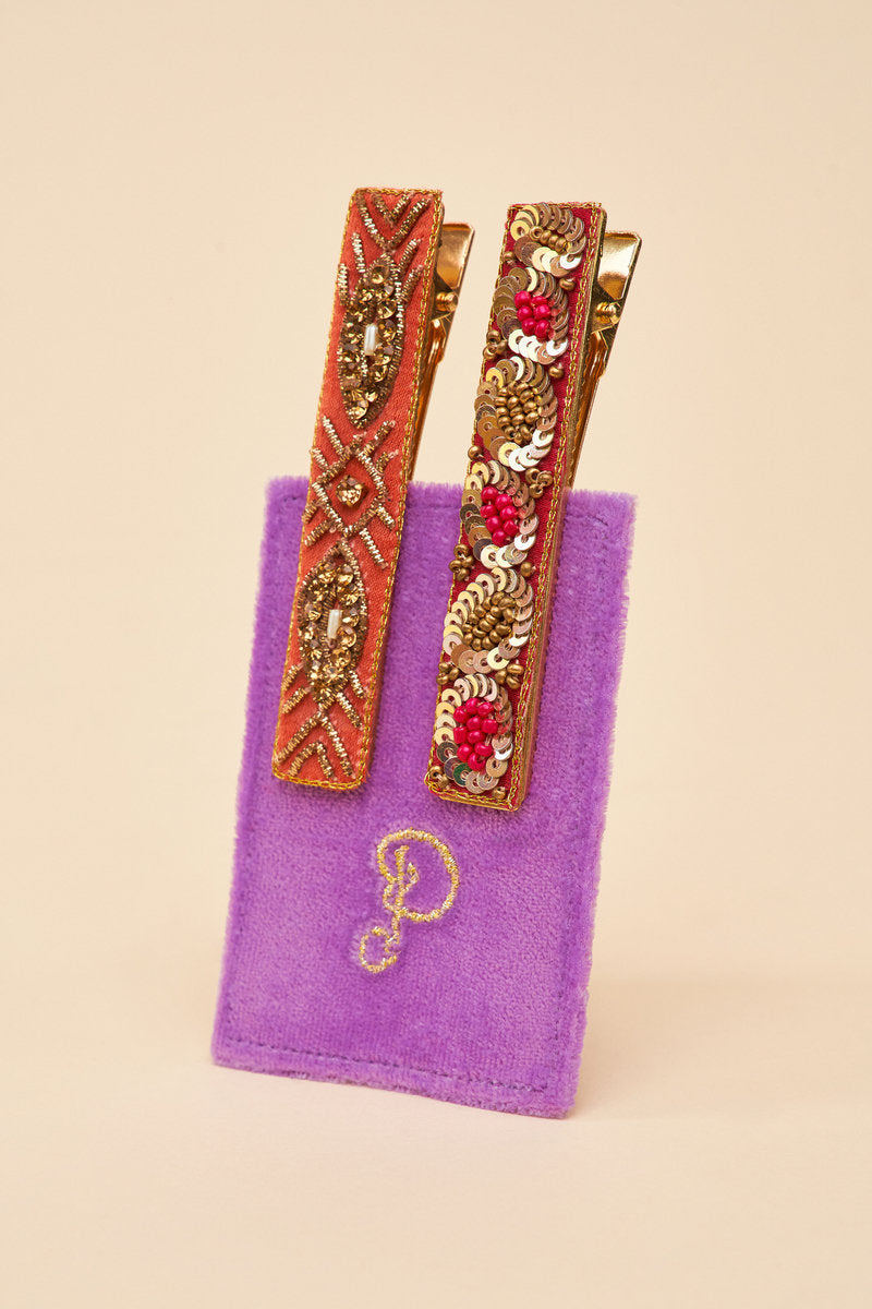 Two jewelled clips on a velvet presentation card