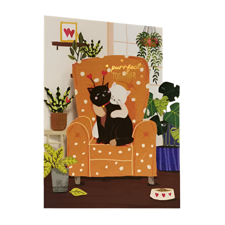 A cat lovers card featuring two cats cuddling on a comfy chair