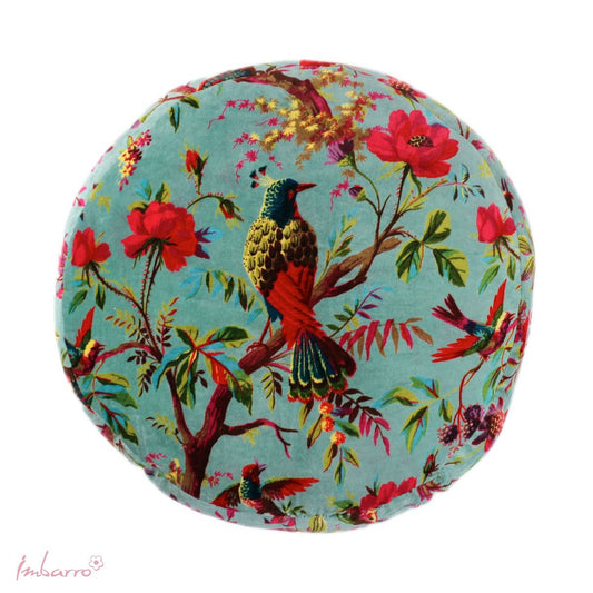 A round velvet cushion with a colourful pattern. The pattern depicts some colourful tropical birds and a botanical scene against a lagoon blue colour. A perfect accent piece for your home. It sits well on a plain background or coupled with some plain coloured cushions.