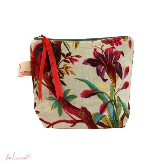 The mint green cosmetic bag is made with a striking designed velour fabric depicting a tropical bird and some botanicals. It has a zipper close.