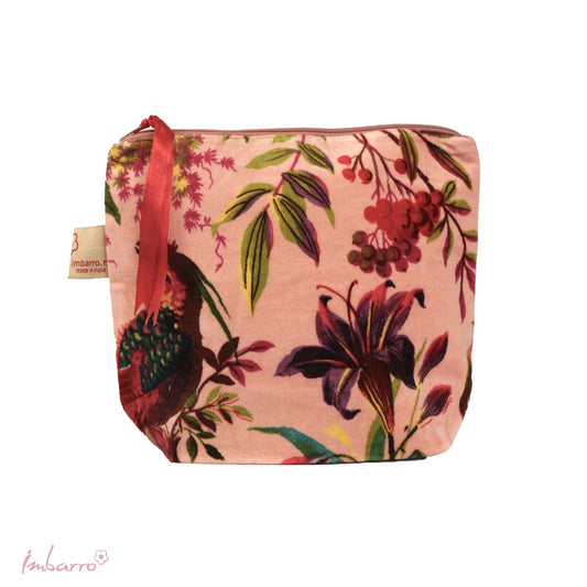 The pink cosmetic bag is made with a striking designed velour fabric depicting a tropical bird and some botanicals. It has a zipper close.