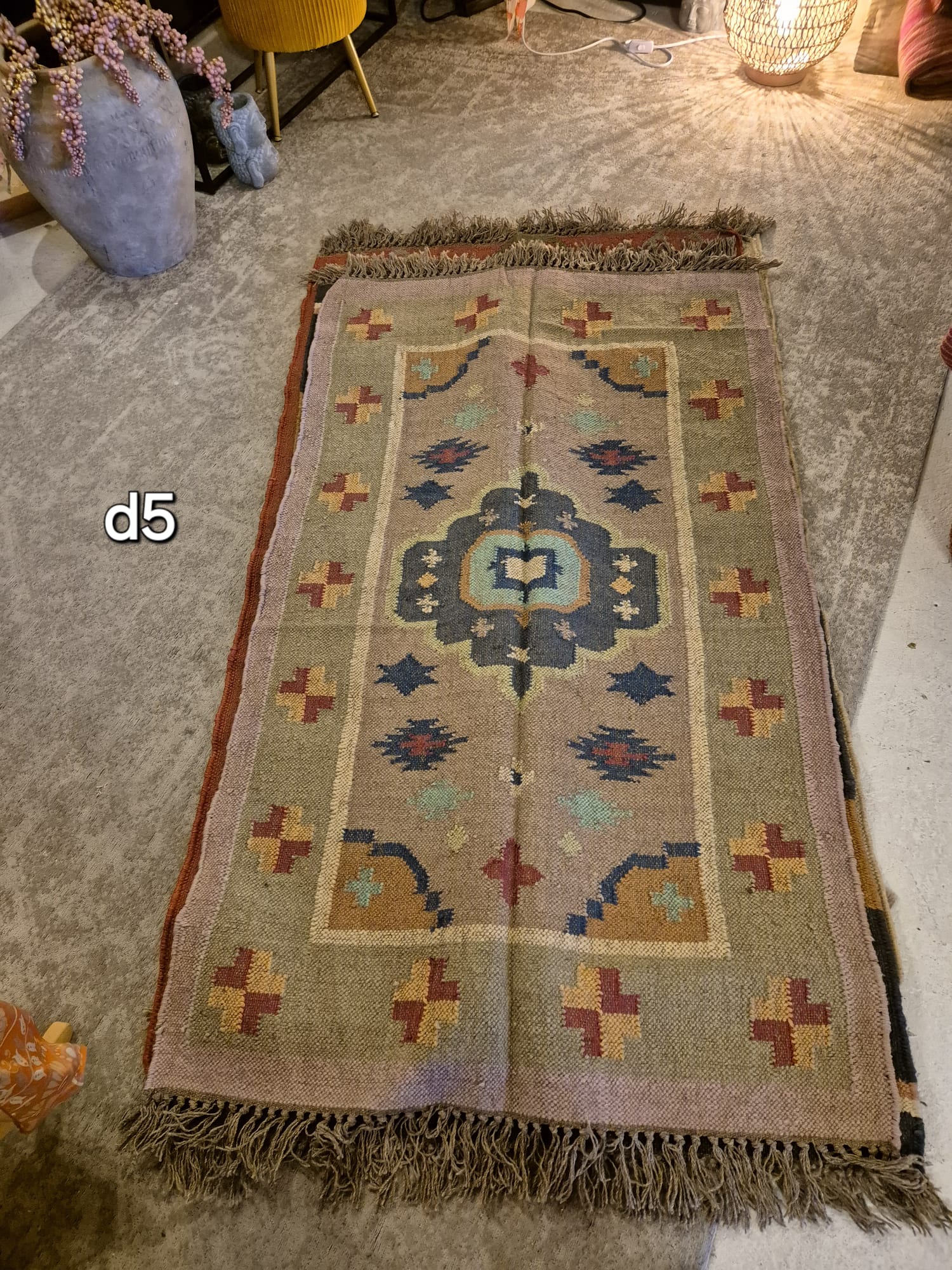 Add a touch of classic elegance to your space with this Kilim Rug (style D5). Handcrafted with jute for a rich and textured look, this rug boasts a beautiful earthy color palette that will bring warmth to any room.