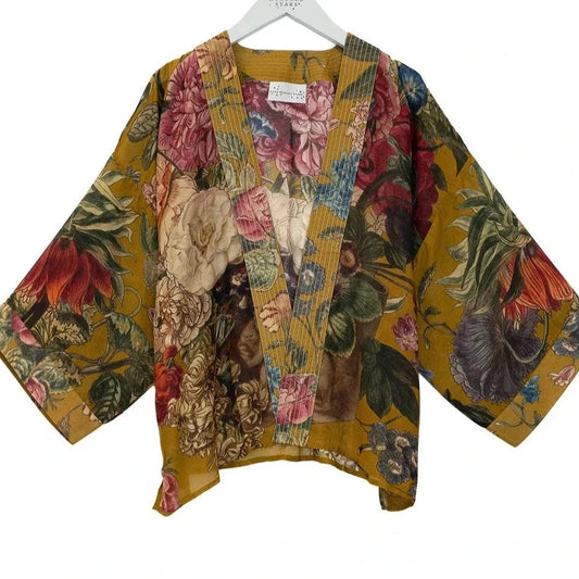 Floral patterned kimono jacket on a hanger against a white background