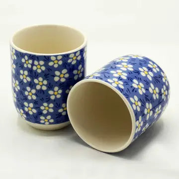 handle less teacup with blue background and flower design in white and yellow