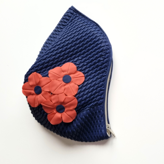 Navy blue retro swim bag made from a vintage style swimming hat. It has three red flowers on the side.