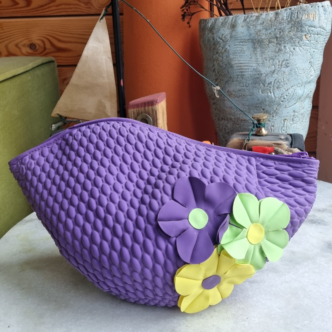 Purple retro swim bag made from a vintage style swimming hat. It has three  flowers on the side.