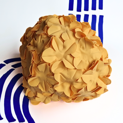 A brightly coloured orange swimming hat , completely covered in flowers of the same colour.