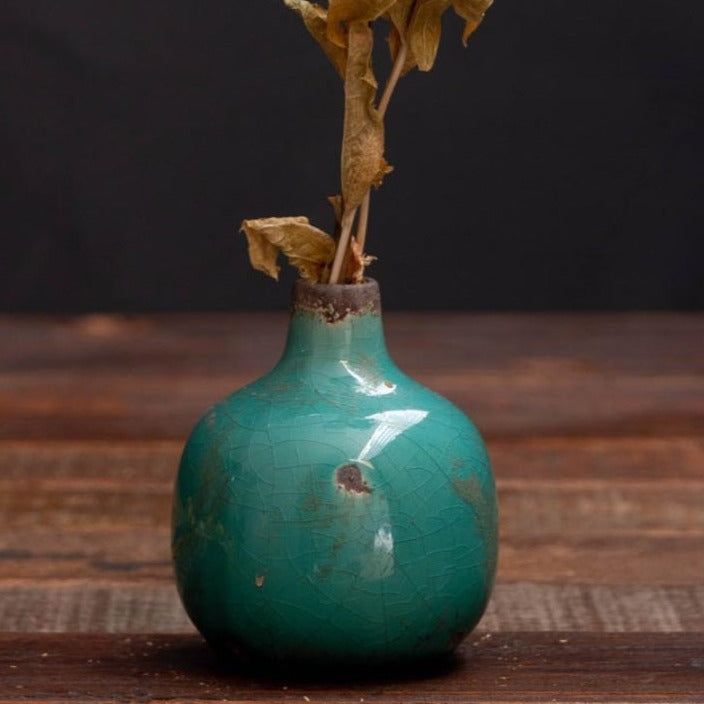 Turquoise green bud vase with a distressed glaze. Lovely on its own and equally effective visually in a grouping of three at different heights.