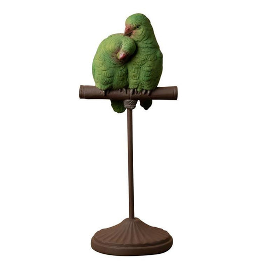 Two green parrots on a perch 