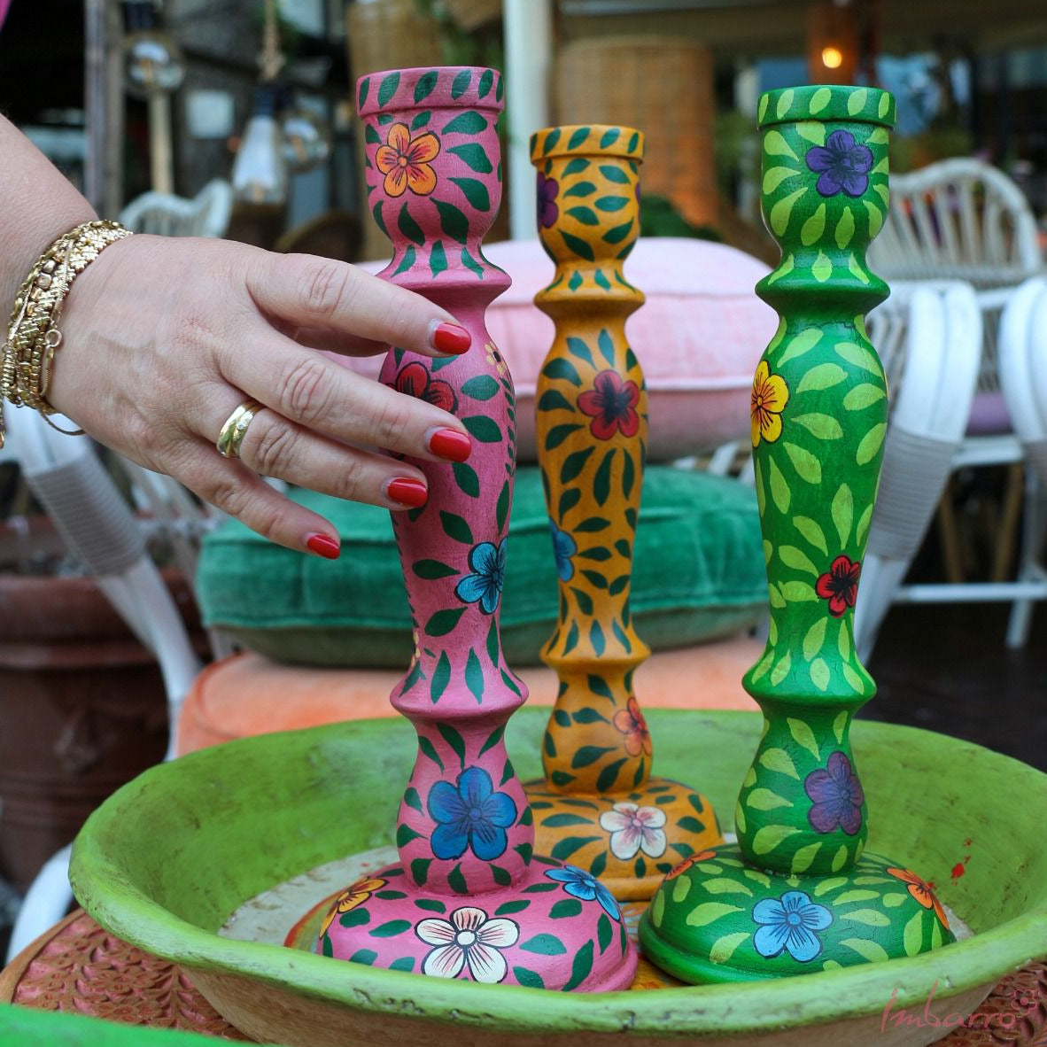 ves and flowers in red blue and yello.  This picture shows pink and yellow candle holders in a green bowl.