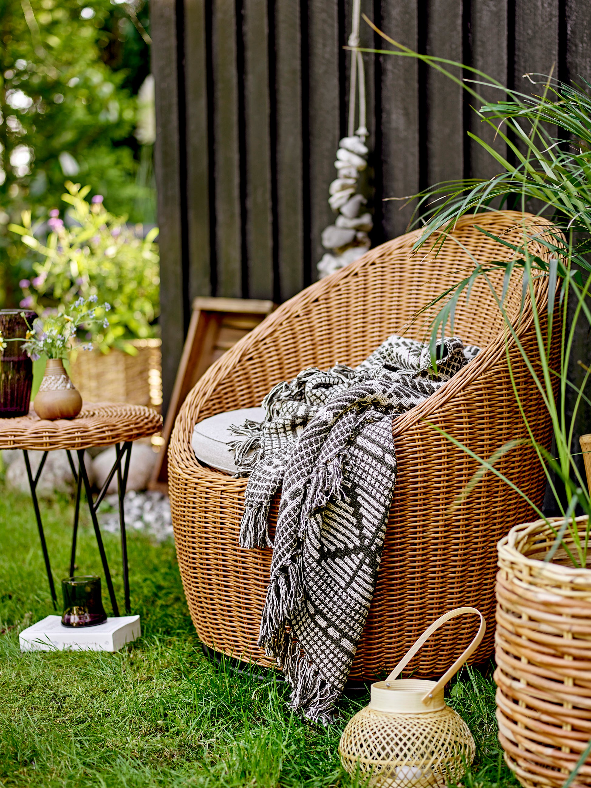 A soft and luxurious throw in gray/green with a decorative pattern and fringe