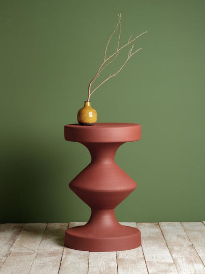 side table in rust with round top and geometrical design